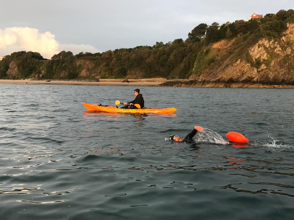 Chris swimming with his safety buoy attached and Ryan in his orange Kayak alongside him.